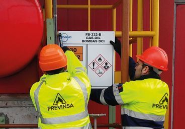 Previnsa proyectos integrales de señalización industrial. Operarios de Previnsa colocando un cartel.